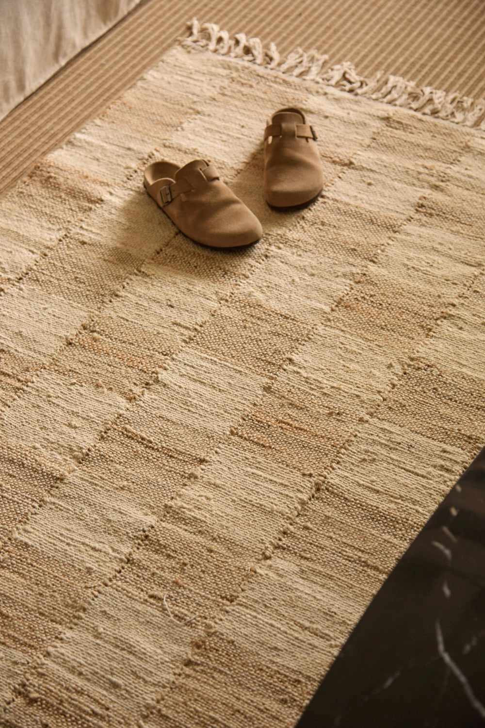 Alfombra de yute natural teñido, con trenzado artesanal y diseño a cuadros