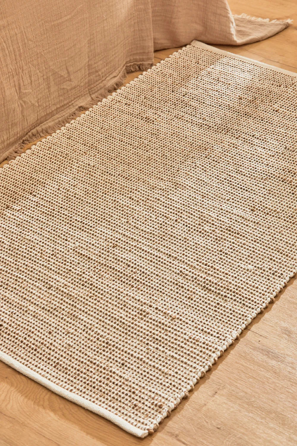 Alfombra de yute y algodón color crudo, con trenzado artesanal y una textura natural