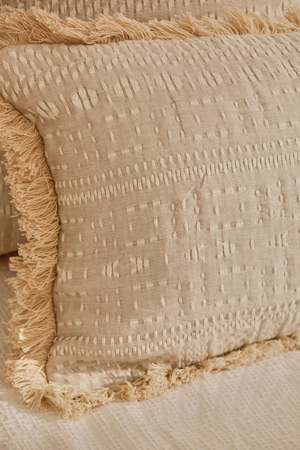 Funda cojín rectangular algodón jacquard beige con detalles en crudo y acabado en flecos detalles cosido