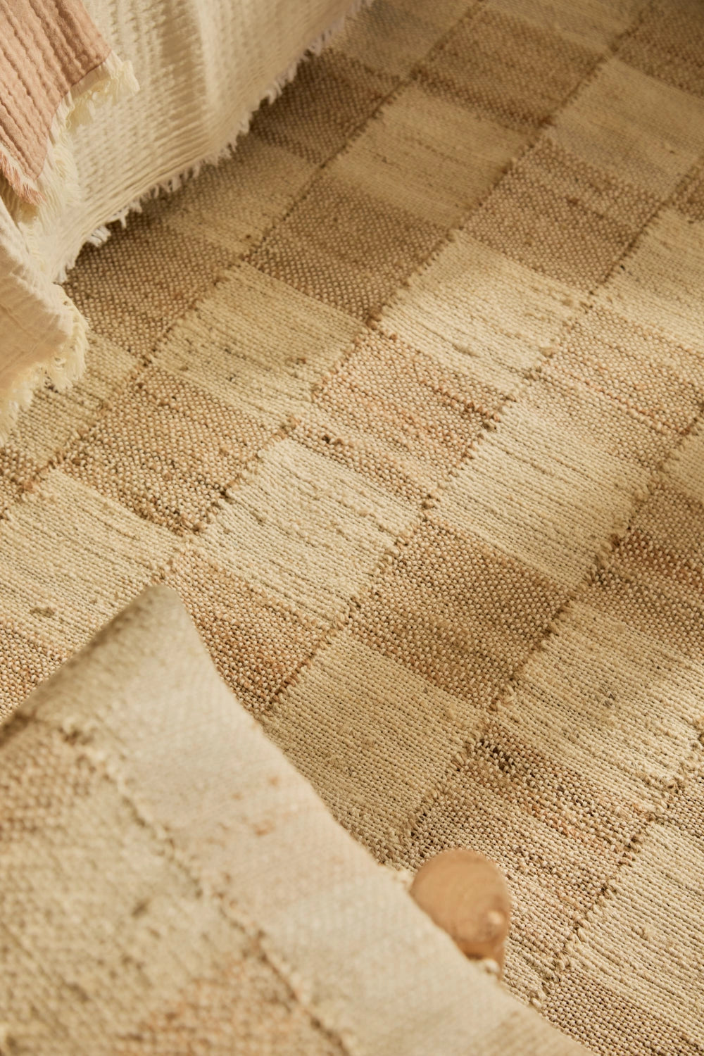 Alfombra de yute natural teñido, con trenzado artesanal y diseño a cuadros
