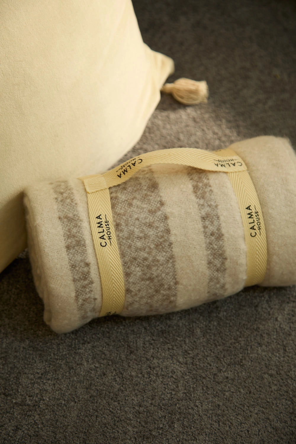 Manta para sofá en tono crudo con rayas beige detalle calma