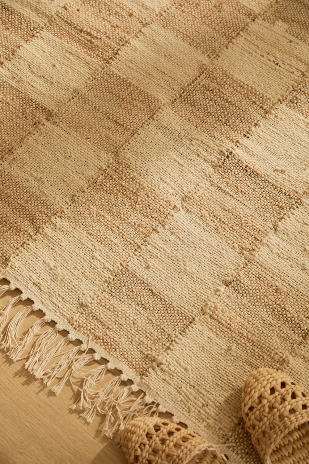 Alfombra de yute natural teñido, con trenzado artesanal y diseño a cuadros detalle