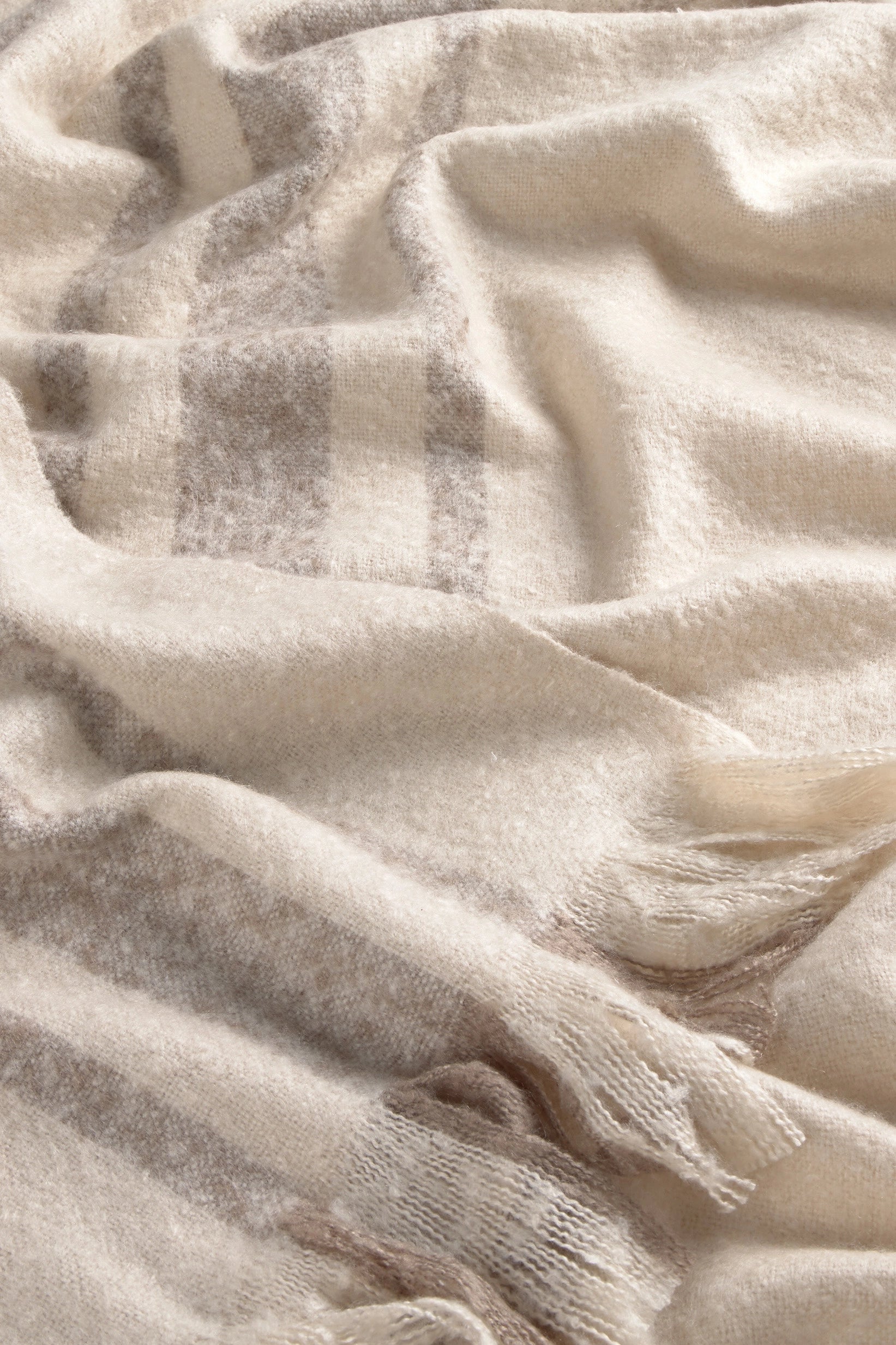 Manta para sofá en tono crudo con rayas beige detalle tela