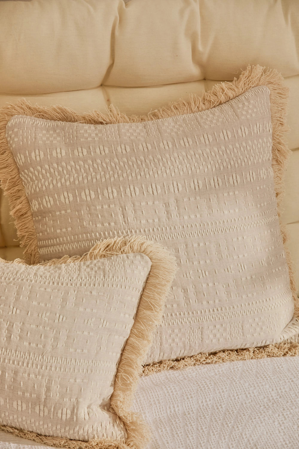 Funda cojín 60x60 de algodón jacquard beige con detalles en crudo y acabado en flecos
