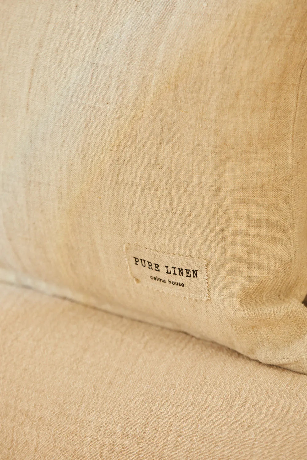 Funda cojín rectangular puro lino beige, con una textura suave y natural detalle calma