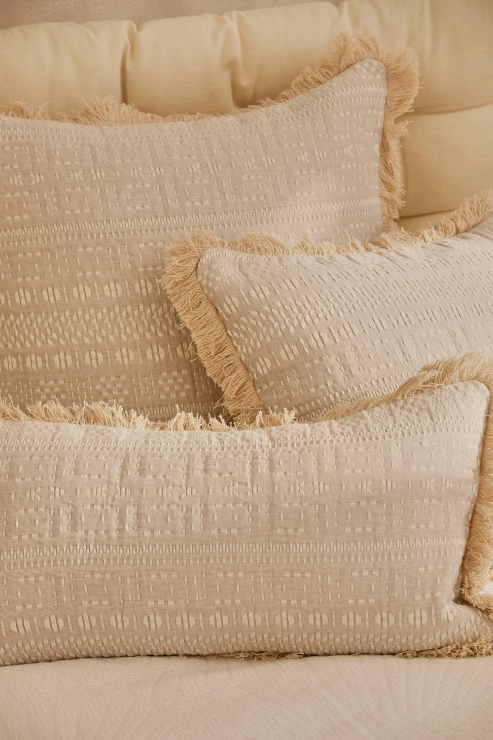 Fundas cojín de algodón jacquard beige con detalles en crudo y acabados en flecos