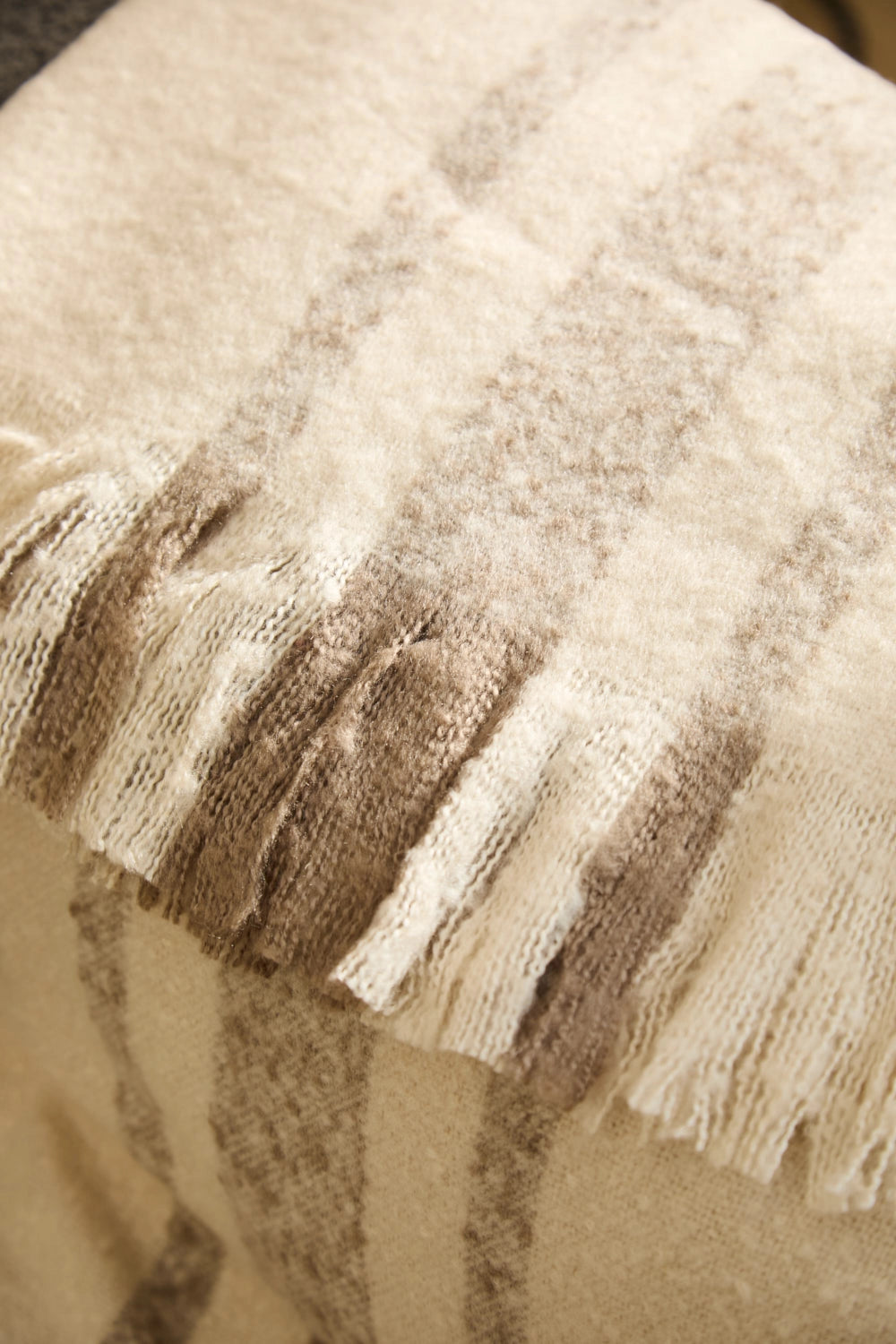 Manta para sofá en tono crudo con rayas beige detalle puntas