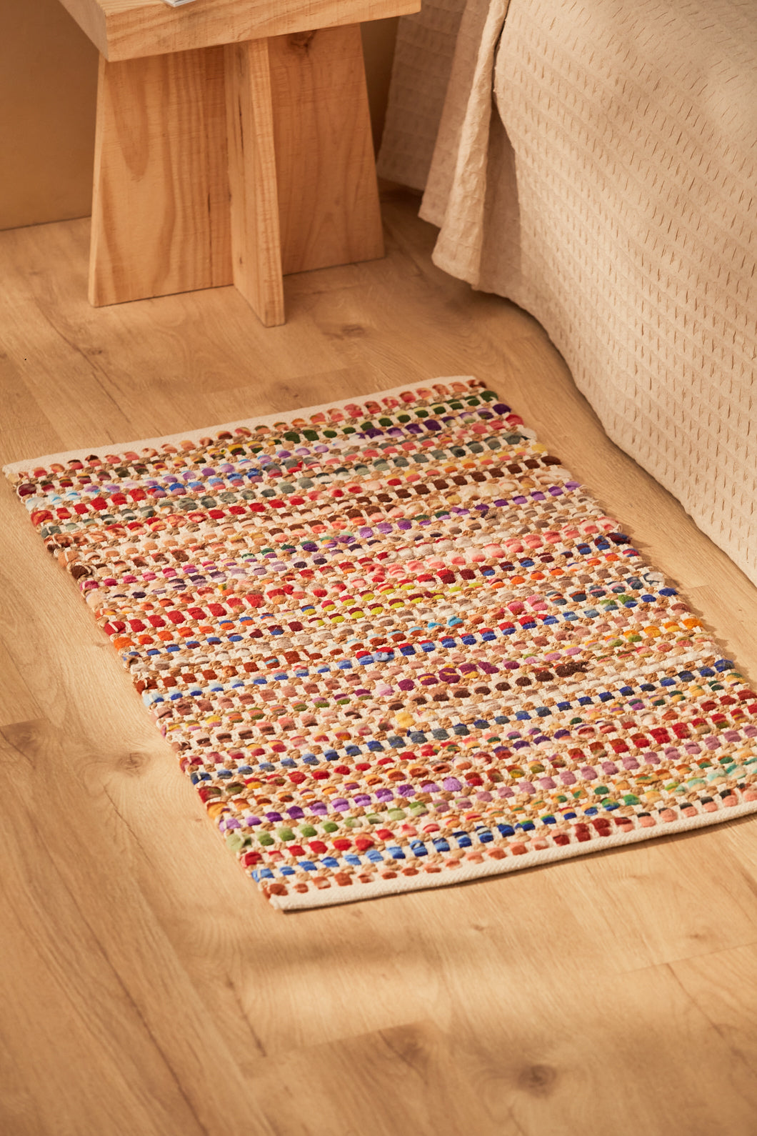Alfombra roja de yute y fibras sintéticas multicolor con acabado chindi y trenzado artesanal.
