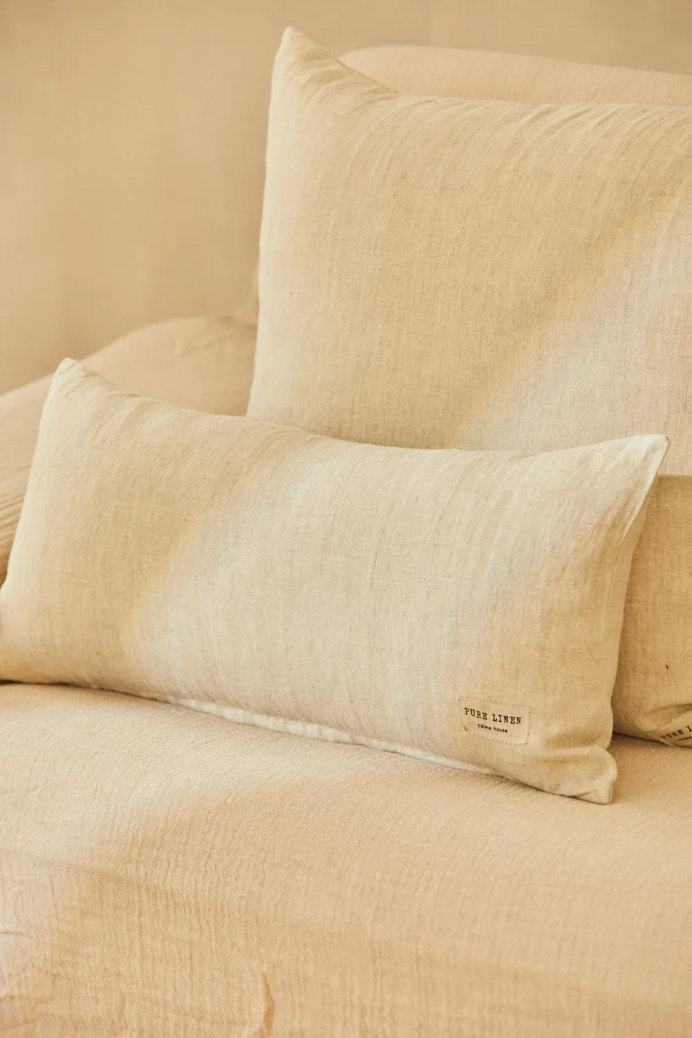 Funda cojín rectangular puro lino beige, con una textura suave y natural