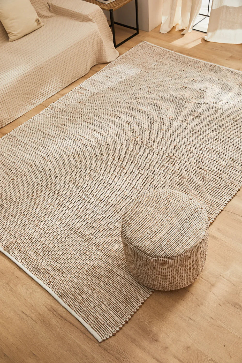 Alfombra de yute y algodón color crudo, con trenzado artesanal y una textura natural