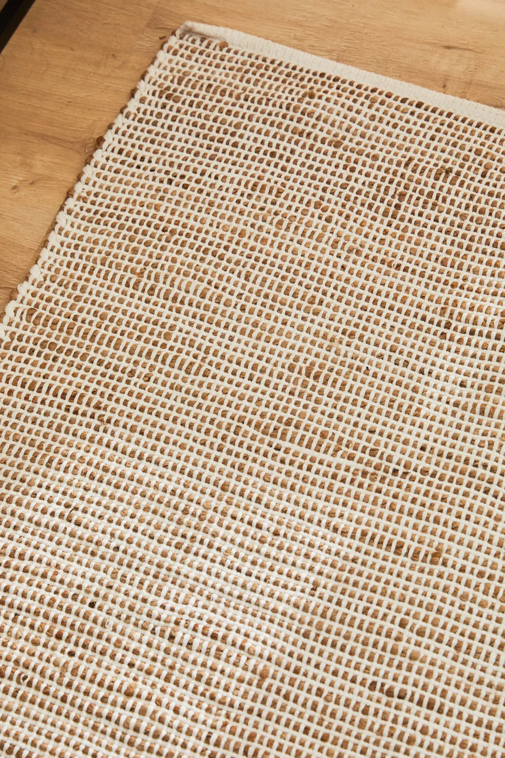 Alfombra de yute y algodón color crudo, con trenzado artesanal y una textura natural