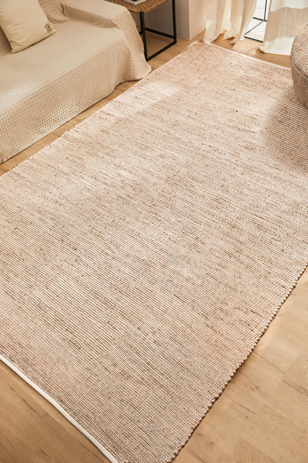 Alfombra de yute y algodón color crudo, con trenzado artesanal y una textura natural